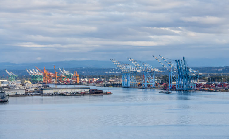 The wharf at the Port of Tacoma with many cranes for shipping.