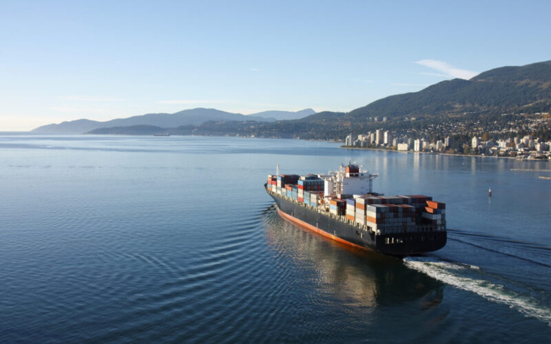 Aerial photo of a loaded container ship leaving port.